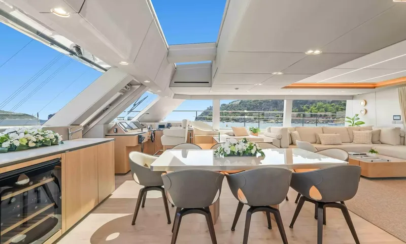 Amitatu: Indoor dining table with grey chairs near the helm station and saloon lounge
