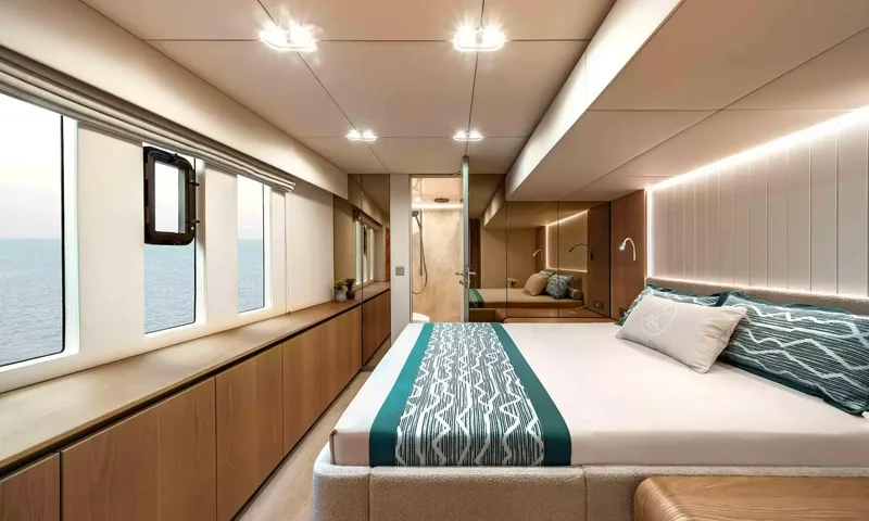 Amitatu: Cabin with double bed, teal bed runner, sea view windows and ensuite beyond