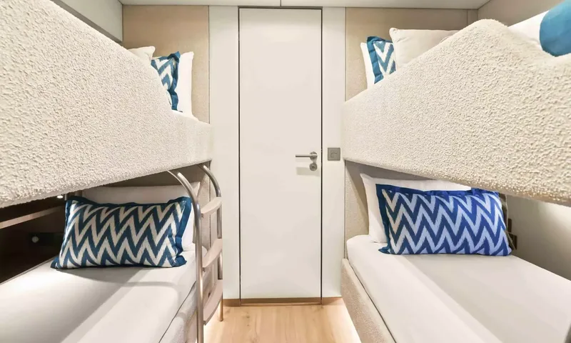 Amitatu: Twin bunk bed cabin with blue zigzag cushions and a central door