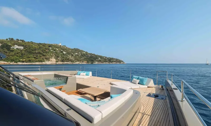 Amitatu: Foredeck lounge with jacuzzi and sunbeds facing a green headland and open sea