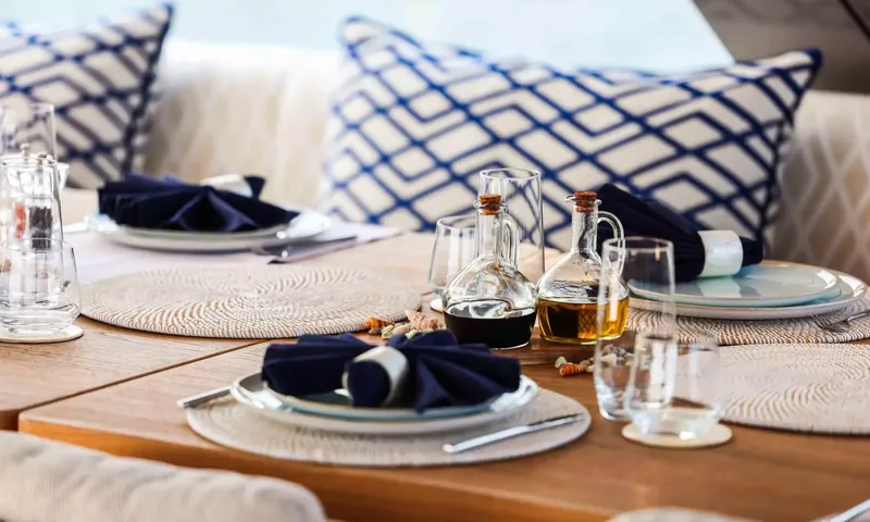 Amitatu: Close view of table settings with folded navy napkins, glasses and oil and vinegar bottles