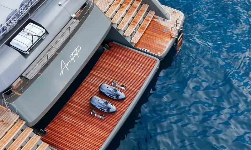 Amitatu: View from above of a teak stern platform holding two underwater scooters beside steps