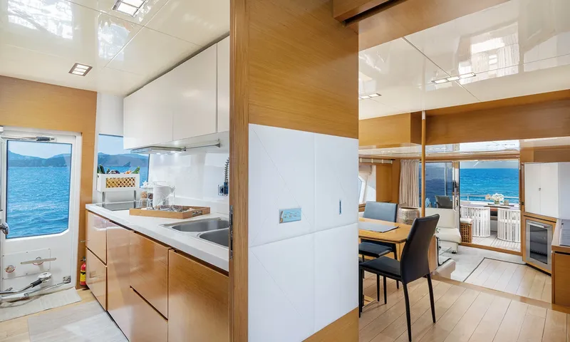 Enjoy I: Cozinha com armários brancos e pia ao lado de uma vista para a área de jantar