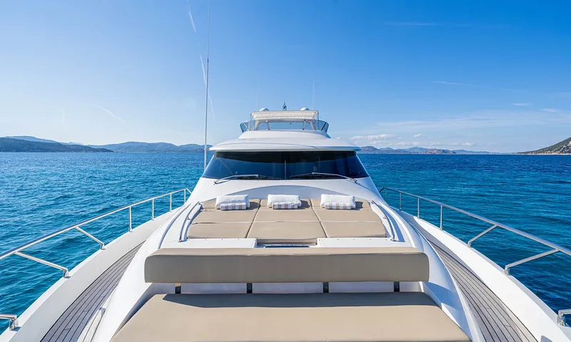Enjoy I: Colchonetes de sol do convés de proa com toalhas, olhando de volta para o para-brisa e o flybridge