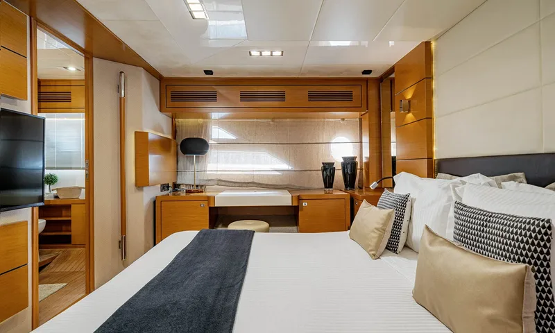 Enjoy I: Cabine vista da cama em direção a uma penteadeira, uma televisão e a porta do banheiro privativo