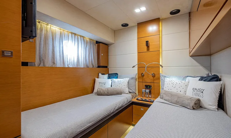 Enjoy I: Cabine twin com camas de solteiro listradas, almofadas decorativas, luzes de leitura e janela com cortinas