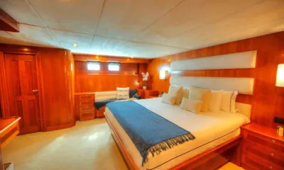 Voyager I: Camarote con cama grande, manta azul, cabecero acolchado y revestimiento de madera