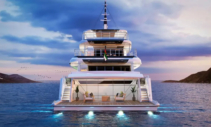 Yoto: Stern view of the yacht at dusk with open beach club lounge and glowing underwater lights
