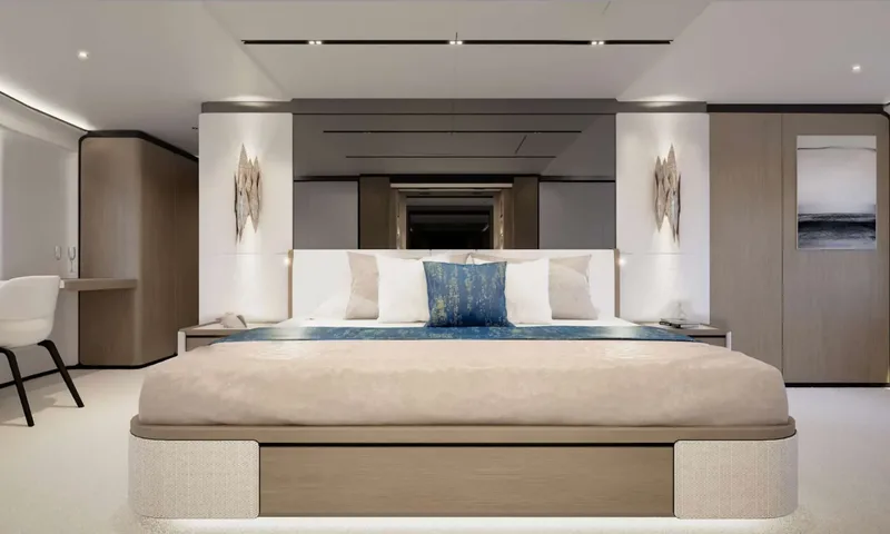 Yoto: Front view of a large double bed with wall sconces and a desk chair