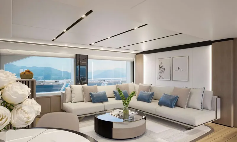 Yoto: Corner sofa with blue cushions and round coffee table beside large windows