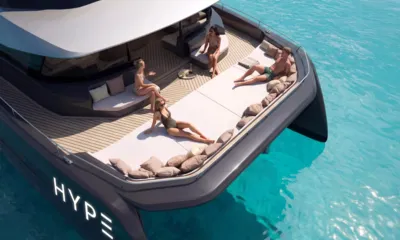 HYP3: Guests relaxing on large cushioned sunpad on the bow deck over turquoise water
