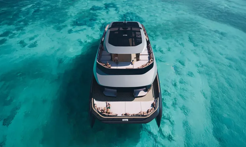 HYP3: Drone view from above the bow of catamaran anchored in shallow turquoise water