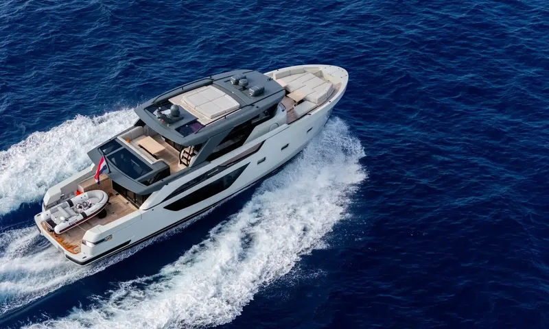 Jamon: Aerial view of the yacht under way with white wake and a small tender on the aft deck