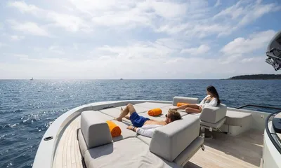 Jamon: Two guests relaxing on foredeck sunpads facing the open sea