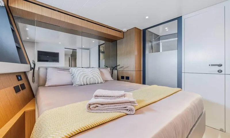 Jamon: Double cabin with folded towels on the bed, wood panelling and a mirrored wall