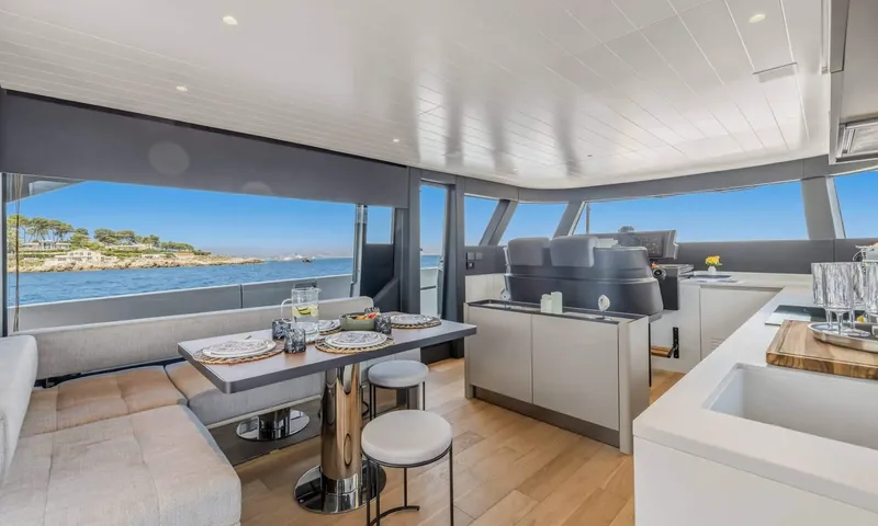 Jamon: Set dining table with bench seating near the helm and galley counter, sea views