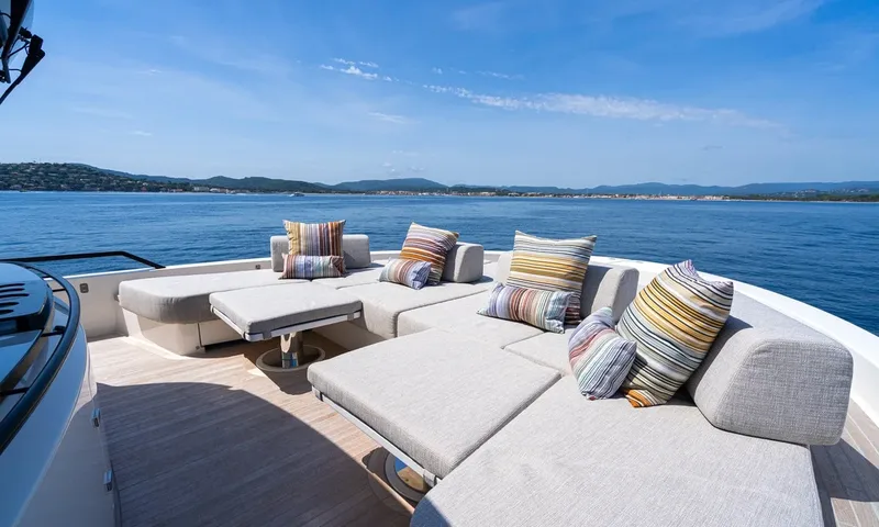 CC: Large grey lounge with striped cushions on the foredeck overlooking the sea