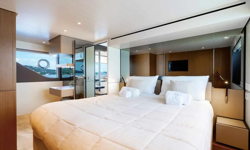 CC: Bright cabin with large white bed, towels, television and window view of the coast