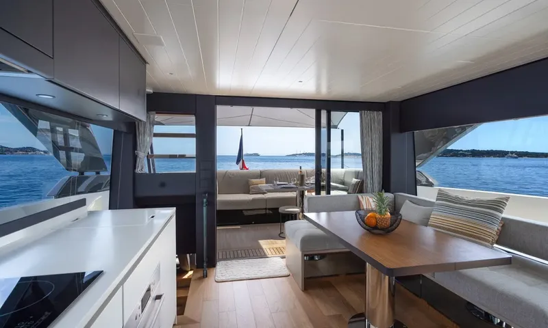 CC: Interior dining area and galley looking aft through open doors to the aft deck