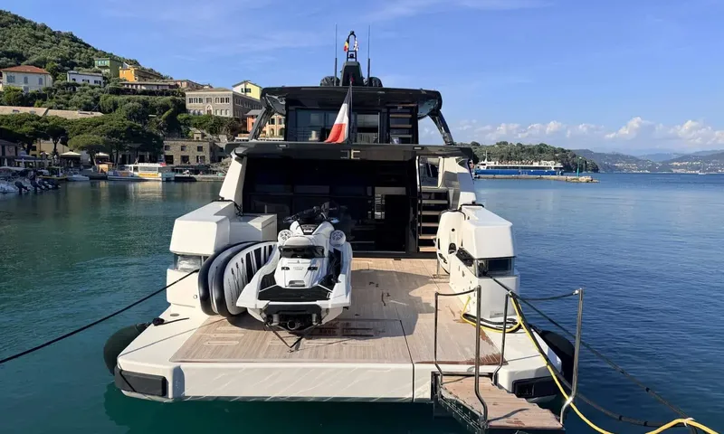 CC: Stern of the moored yacht with a jet ski and towable on the aft deck