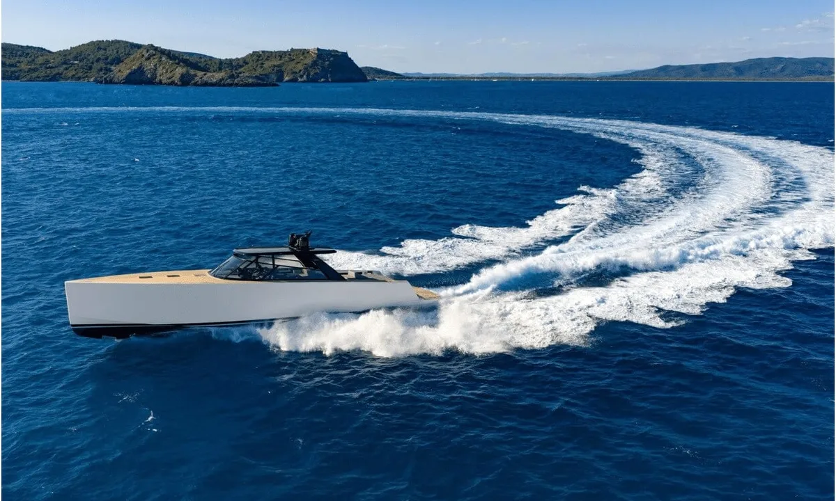 Dutch Pearl: White motor yacht with teak deck carving a curved wake across deep blue sea near green hills
