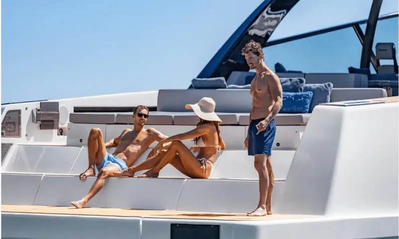 Dutch Pearl: Three guests in swimwear relaxing on cushioned steps at the yacht's stern
