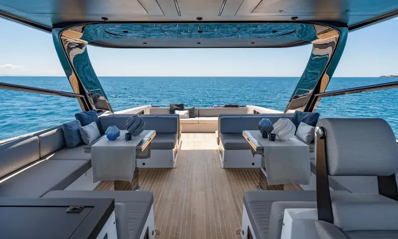 Dutch Pearl: Covered aft deck with facing sofas and tables on teak flooring, open sea behind