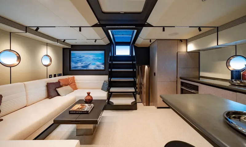 Dutch Pearl: Lower lounge with cream corner sofa, coffee table, stairs to deck and kitchen counter