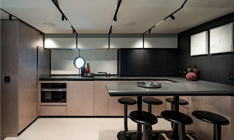 Dutch Pearl: Modern kitchen with grey counters, oven, breakfast bar and four black stools