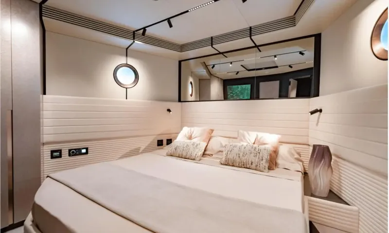 Dutch Pearl: Cabin with double bed, cream padded walls, porthole and wide mirror above the headboard