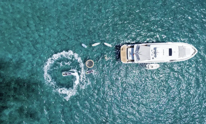 Louder: Top down view of the yacht at anchor with tender, jet skis, paddleboards and floating trampoline