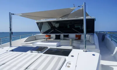 Louder: Foredeck with striped sunpads and a shaded lounge with seating and tables