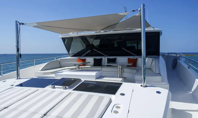 Louder: Foredeck with striped sunpads and a shaded lounge with seating and tables