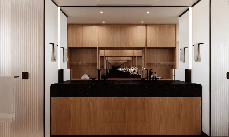 Aitana: Bathroom vanity with black stone counter, wood cabinets and a wide mirror