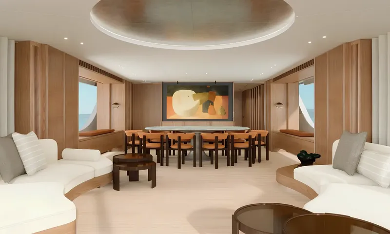 Aitana: Bright saloon with curved white sofas leading to a dining table with orange chairs and artwork