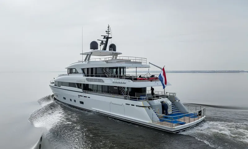 Lumière: Elevated stern view of a white yacht under way, showing aft decks and swim platform