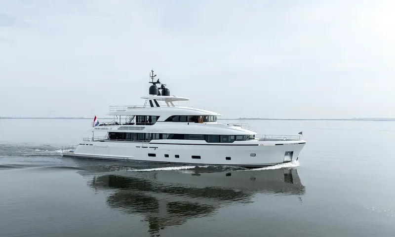 Lumière: White yacht cruising on flat grey water with its reflection below