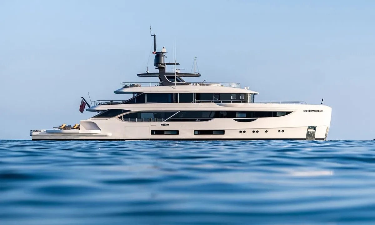 Wavė: Weiße Yacht im Seitenprofil vor Anker auf ruhigem blauem Meer unter klarem Himmel