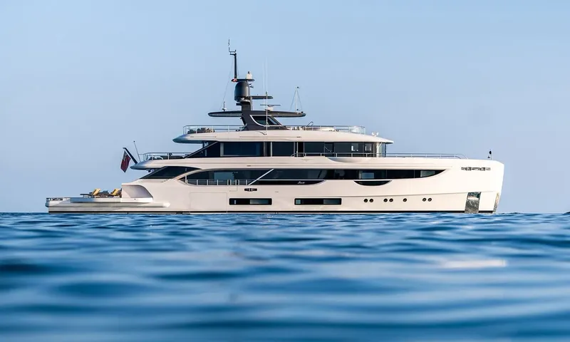Wavė: Weiße Yacht im Seitenprofil vor Anker auf ruhigem blauem Meer unter klarem Himmel