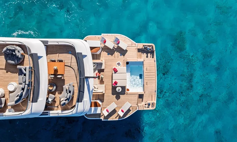 Wavė: Draufsicht auf die Hecksdecks mit Esstisch, Loungesitzplätzen, Liegen und Pool