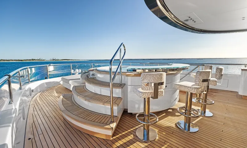 Wavė: Oberdeck mit erhöhtem Jacuzzi, geschwungenen Stufen und Barhockern um eine Bar mit Glasplatte