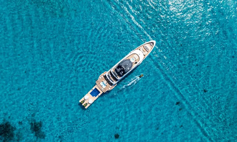 Wavė: Draufsicht auf die Yacht in türkisfarbenem Wasser mit schwimmender Pool-Plattform und Jetski