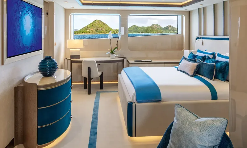 Amor à Vida: Cabin with blue accented double bed, desk and windows looking at green hills