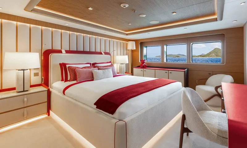 Amor à Vida: Cabin with red trimmed double bed, armchair and windows showing islands
