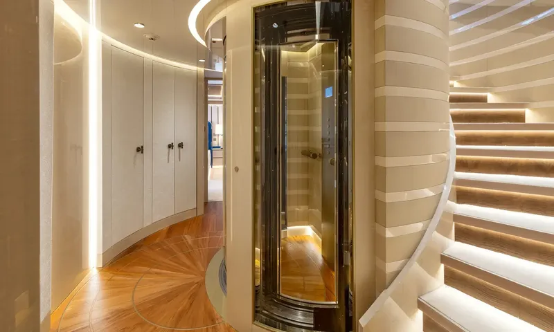 Amor à Vida: Curved lobby with glass lift, wardrobe doors and lit spiral staircase