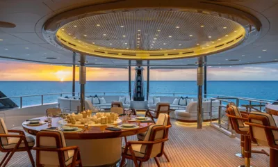 Amor à Vida: Outdoor dining table set under a lit ceiling at sunset over the sea