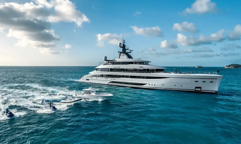 Amor à Vida: White superyacht on turquoise sea with a tender and two jet skis speeding alongside