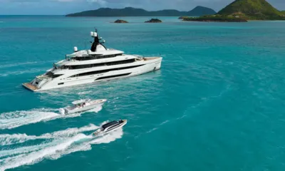 Amor à Vida: Yacht at anchor in turquoise water with two tenders speeding alongside near green islands