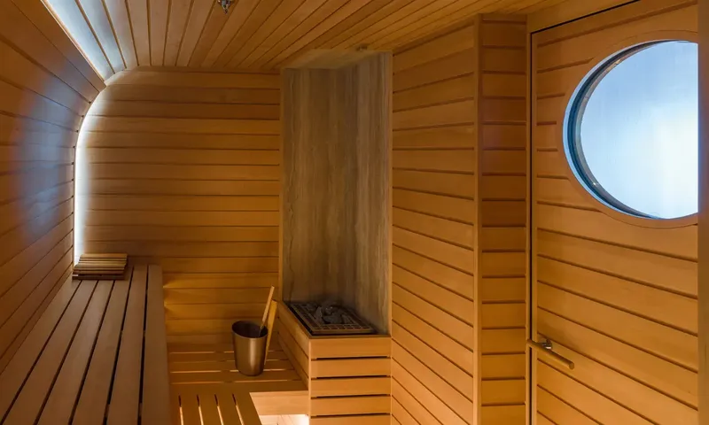 Amor à Vida: Wooden sauna with slatted benches, heater stones, bucket and a round door window