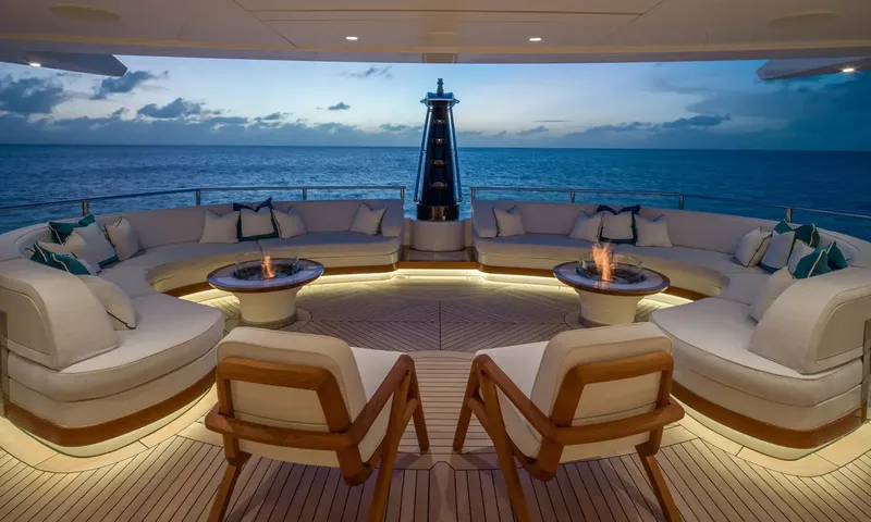 Amor à Vida: Curved cream sofas around two fire pits on an aft deck overlooking the sea at dusk